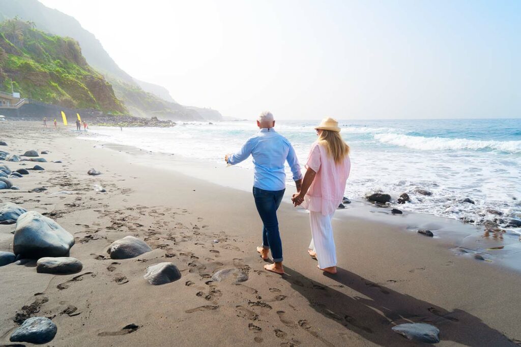 Lifestyle with senior couple walking on beach
