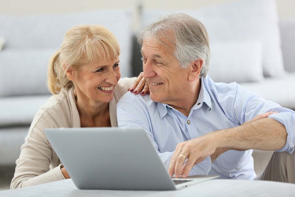 Senior couple websurfing on internet with laptop